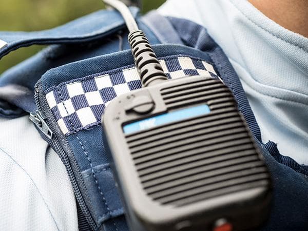 Police officer using modern communication equipment - PoliceCMS helps law enforcement communicate effectively
